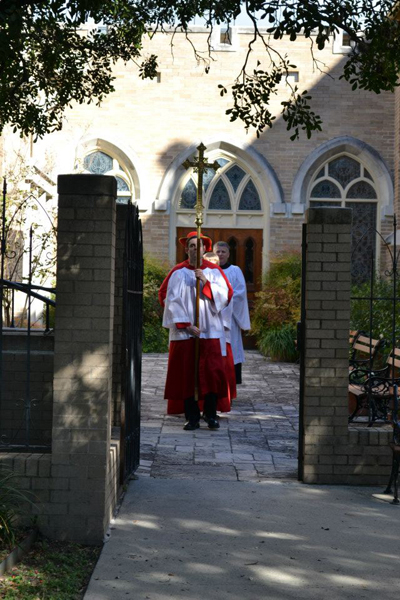Processional cross and clergy entering a church
